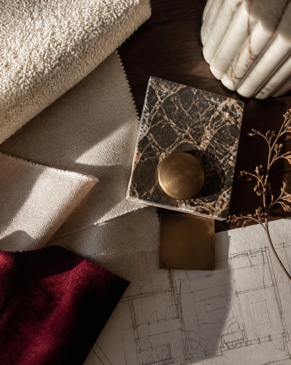 Layered textiles, stone and brass selected by LMC Interiors